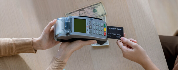Customer using credit card for payment to receptionist. cashless technology and credit card payment...