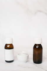 On the table next to the bowl and a cotton swab are two glass bottles for face peeling in the cosmetologist's office