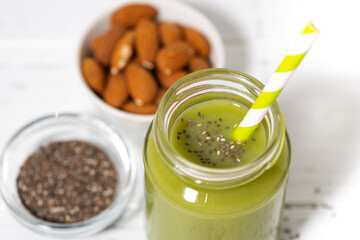 healthy superfood - green smoothie with chia seeds on white table