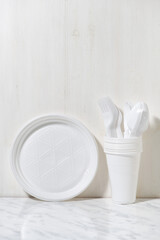 plastic disposable tableware on white background, vertical