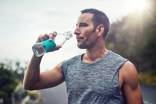 Thinking, athlete and man drinking water on break to hydrate or relax for healthy energy in exercise. Tired, fatigue and thirsty male runner with liquid or fitness in marathon training or workout