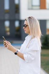 Young girl with a smartphone in her hands on the street