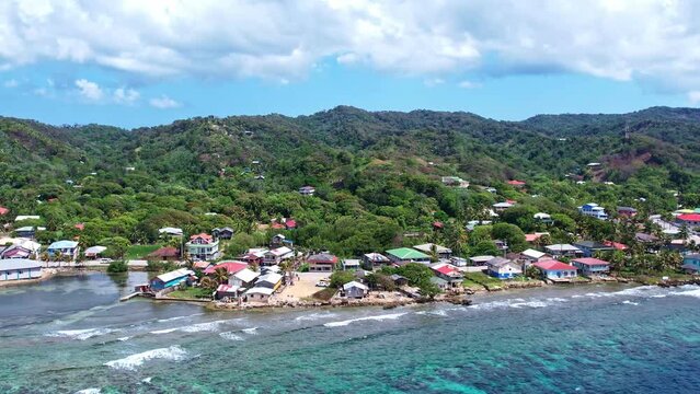 4k resolution drone video of buildings and homes on the coastline of roatan honduras in the caribbean
