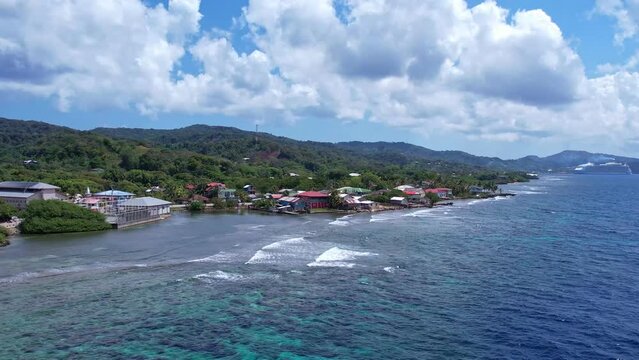 4k resolution drone video of buildings and homes on the coastline of roatan honduras in the caribbean
