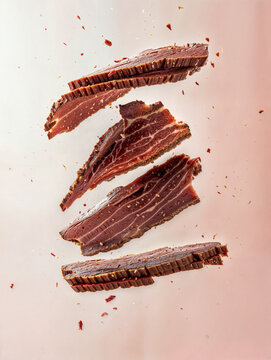 Several slices of pastrami suspended in the air against a white background, colliding with each other