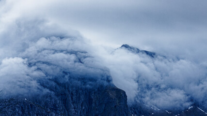 Mountain Island. Mountain peaks shrouded in sea fog on a cloudy day. Lofoten Islands, Norway. 