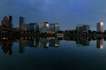 Fototapeta premium City skyline and water reflections on a serene river surface