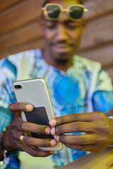 African American Teenager in Traditional Sudanese Attire Engaged with Smartphone
