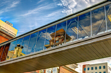 Reflection of a clock tower in a glass street overpass