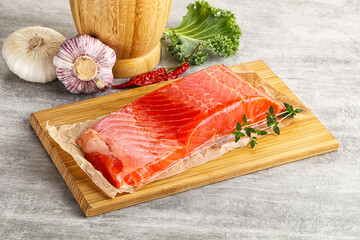 Raw salmon fillet over board