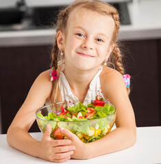 Little girl eating vegetable salad