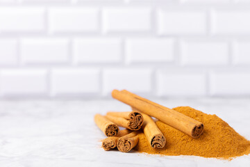 Ceylon cinnamon.Cinnamon sticks on a textured wooden background. Cinnamon roll and powder. Spicy spice for baking, desserts and drinks. Fragrant ground cinnamon. Close-up. Place for text. copy space