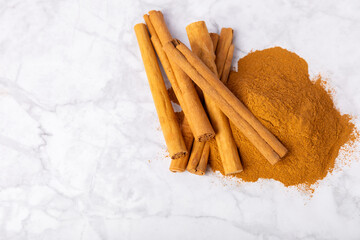 Ceylon cinnamon.Cinnamon sticks on a textured wooden background. Cinnamon roll and powder. Spicy spice for baking, desserts and drinks. Fragrant ground cinnamon. Close-up. Place for text. copy space