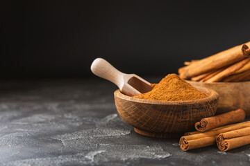 Ceylon cinnamon.Cinnamon sticks on a textured wooden background. Cinnamon roll and powder. Spicy...