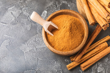 Ceylon cinnamon.Cinnamon sticks on a textured wooden background. Cinnamon roll and powder. Spicy spice for baking, desserts and drinks. Fragrant ground cinnamon. Close-up. Place for text. copy space