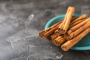 Ceylon cinnamon.Cinnamon sticks on a textured wooden background. Cinnamon roll and powder. Spicy...