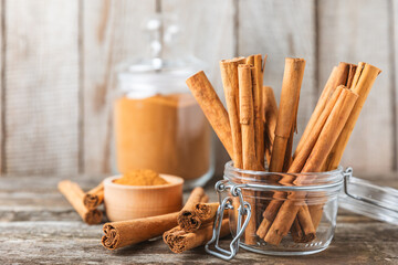 Ceylon cinnamon.Cinnamon sticks on a textured wooden background. Cinnamon roll and powder. Spicy spice for baking, desserts and drinks. Fragrant ground cinnamon. Close-up. Place for text. copy space