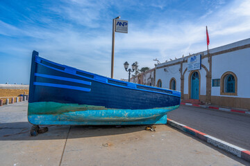 Bright blue boats on land with the ANP building in the background. Symbolizing the maritime...