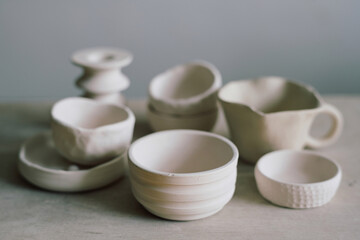 Closeup still life composition of handmade ceramic bowls and mug on table, copy space