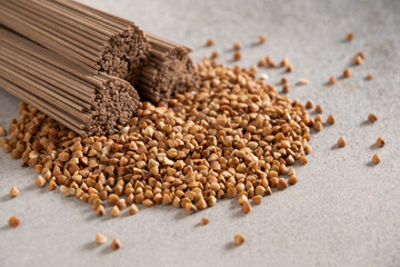 Uncooked buckwheat noodles soba on gray background. Space for text. Healthy vegan diet. Close up....