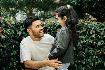 A young father hugging his young daughter