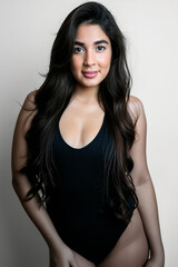 Naklejka premium Girl in black swimsuit on homogeneous light background