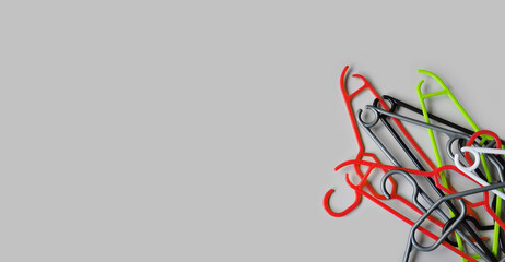 Stacked empty plastic clothes hangers on a light gray background. Minimalism. The concept of modern consumption. Copy space