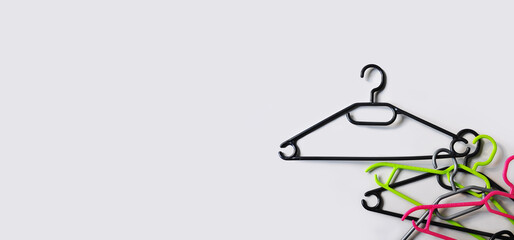Stacked empty plastic clothes hangers on a light gray background. Minimalism. The concept of modern...