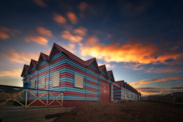 Colorful beach hut on La Arena beach in Muskiz on a nice sunrise with orange clouds