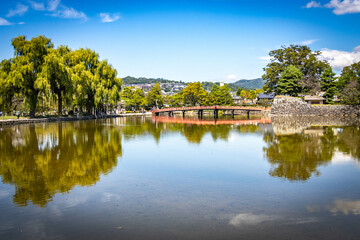 Fototapeta premium red bridge, matsumoto castle, matsumoto, japan, edo period, samurai, ninja, moat, reflection