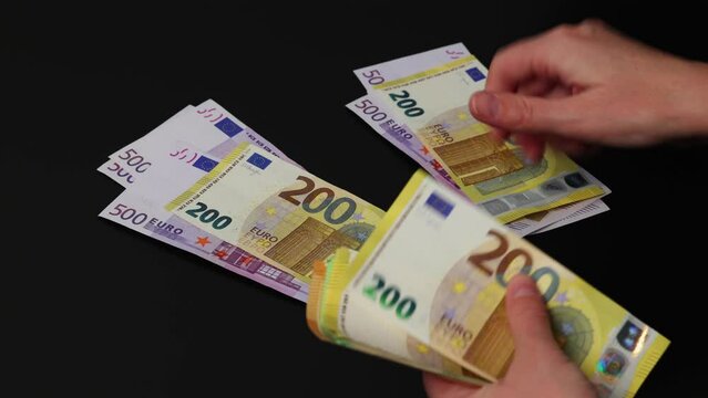 Close-up of a female hands dividing cash into two equal parts