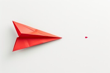 A vibrant red paper airplane isolated on a white background, representing concepts of travel and creativity