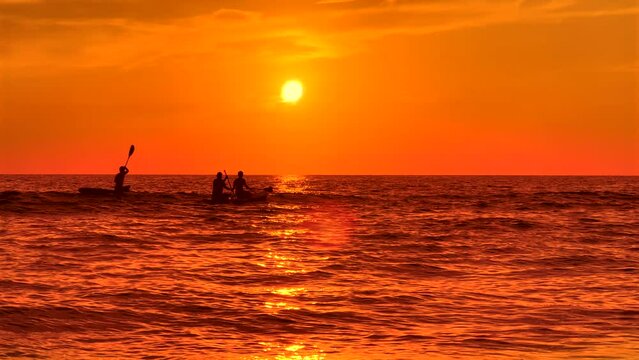 People enjoy canoeing on beach vacation during sunset in Sarasota, Florida