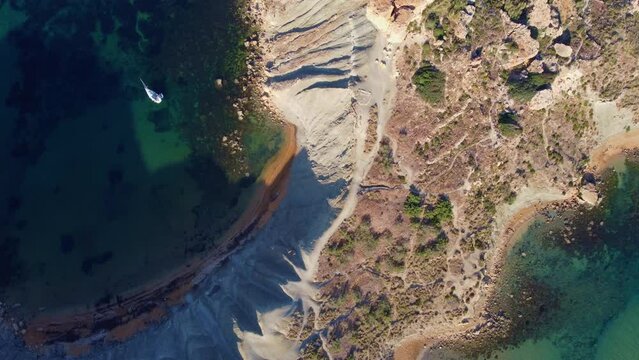 Qarraba Bay flat rock cape Malta, Aeriale stablishing shot in the morning sunlight showing hiking trekking path and two beaches on both side. High quality 4k footage