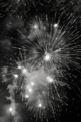 Black and white photograph of fireworks exploding in the night sky