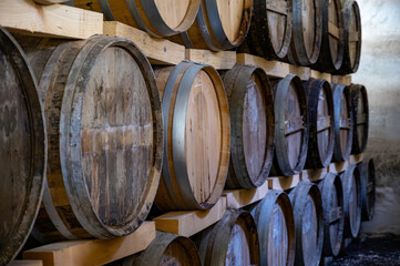 Aging process of cognac spirit in old dark French oak barrels in cellar in distillery house, Cognac white wine region, Charente, Segonzac, Grand Champagne, France