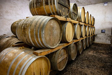 Aging process of cognac spirit in old dark French oak barrels in cellar in distillery house, Cognac...