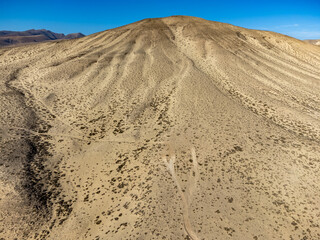 Sandy dunes and hills on Jandia peninsula near Playas de Sotavento en Costa Calma touristic resort, Fuerteventura, Canary islands, Spain