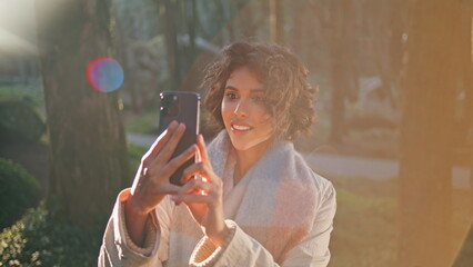 Obraz premium Cheerful woman recording nature beauty on smartphone at morning sunlight closeup