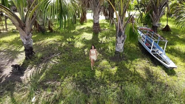 Mujer ind&iacute;gena Atractiva alegre caminando descalza con disfraz t&iacute;pico en la selva Peruana , celebra el D&iacute;a Internacional de los Pueblos Ind&iacute;genas con canciones tradicionales,vestida en top,bonita,