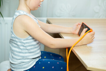young girl maintains good posture while using phone, sitting with straight back, healthy sitting,...