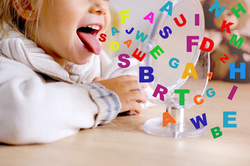 blonde girl of 4 years old girl in front of mirror engaged with speech therapist, gymnastics for tongue, defect, speech disorder with frequent repetition sounds, syllables, spasms muscles apparatus