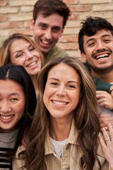 Vertical. Multiracial group of friends outdoors posing smiling and fun. International students together looking happy at camera. Portrait young people from gen Z. Intercultural relations, community