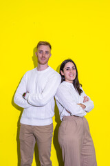 A man and a woman are standing next to each other on a yellow background