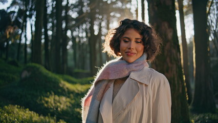 Carefree woman smiling woods greenery sunlit by morning light closeup. Traveler 
