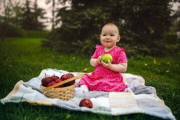 Young Girl in a Pink Dress Enjoying an Apple on a cloudy Day at the Park