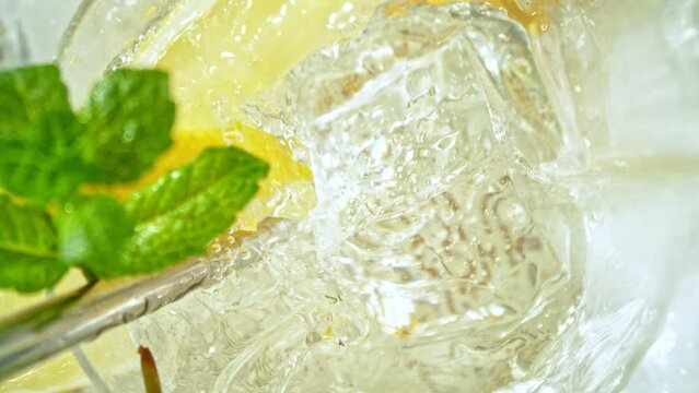 Super Slow Motion Shot of Ice Cube Falling into Glass with Lemonade at 1000fps with Camera Motion.