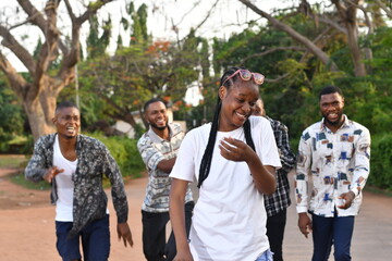 Happy people girls and boys having fun and running outdoors. Smiling students in casual clothes...