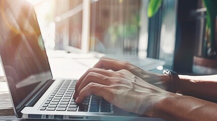Hands typing on a laptop configured for remote work, close-up, detailed view of the workspace setup. 