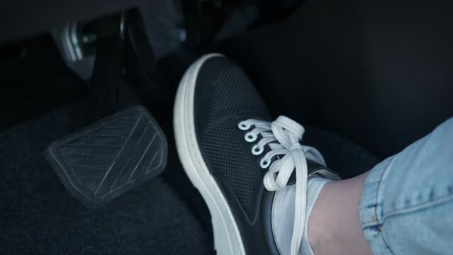 Female foot control the pedals. A view of lady foot on the car pedal during driving time.